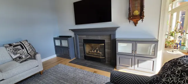Fireplace mantle and built-in cabinets painted slate gray, staged living room