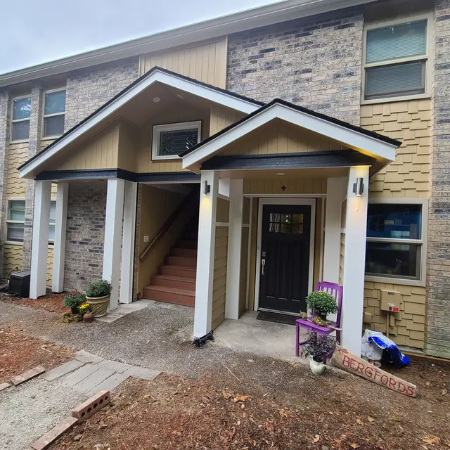 Cream house with dark gabled entryway and black front door