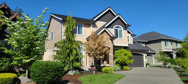 Freshly painted tan two-story home with stone accents