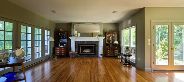 Repainted living room with white-trimmed fireplace and hardwood floors