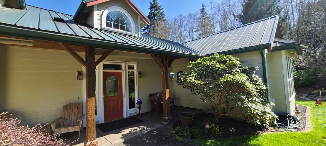 Timber-post entry with a red front door and fresh exterior paint
